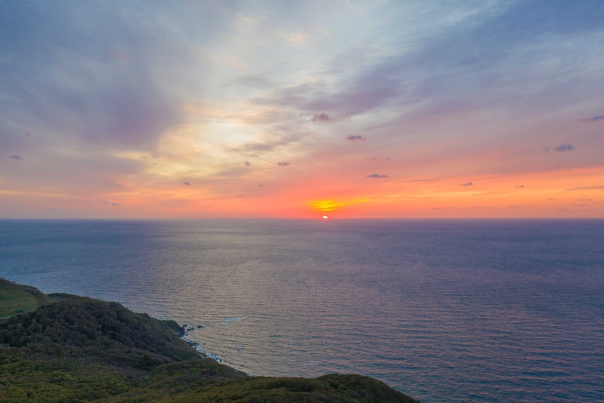 A sunset off a cliff off the coast of Japan