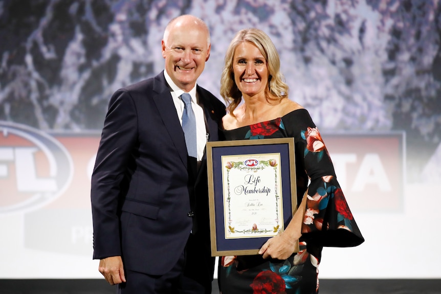 Debbie Lee is presented with her Life Membership by Richard Goyder in 2020.