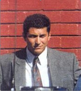 A historic photograph of a Greek man in a suit