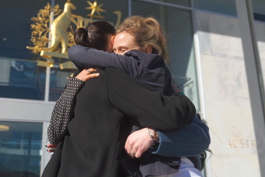 women hugging outside court