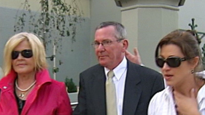 Glenorchy doctor Thomas Foley with his wife and daughter, outside Federal court in Hobart (TV still)