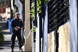 A New South Wales policeman stands guard at the back of of a property in Surry Hills in Sydney.
