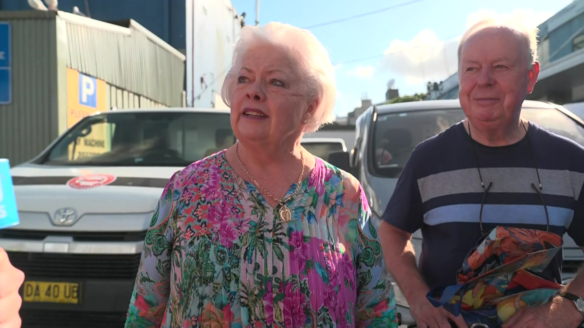 Um homem e uma mulher num estacionamento.