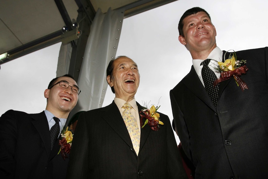 The three men are in suits smiling.