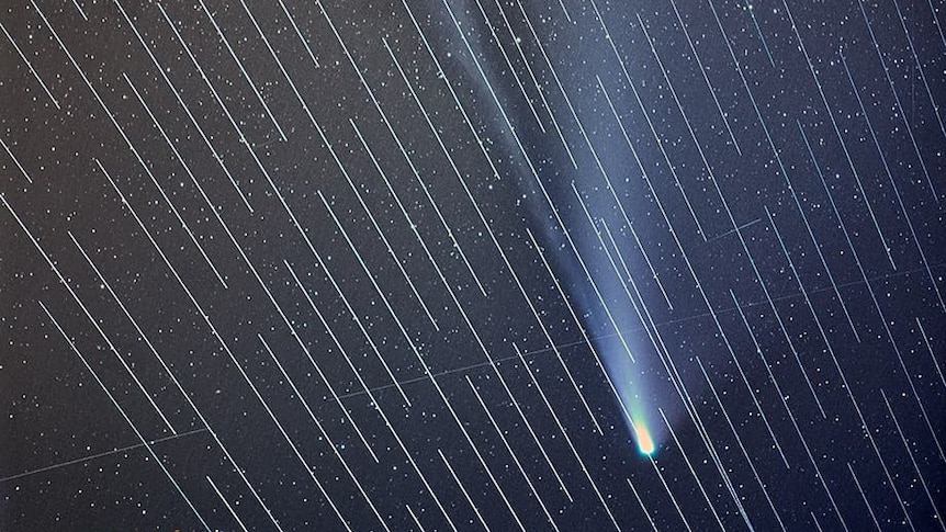 A photo of stars with streaks from satellites.