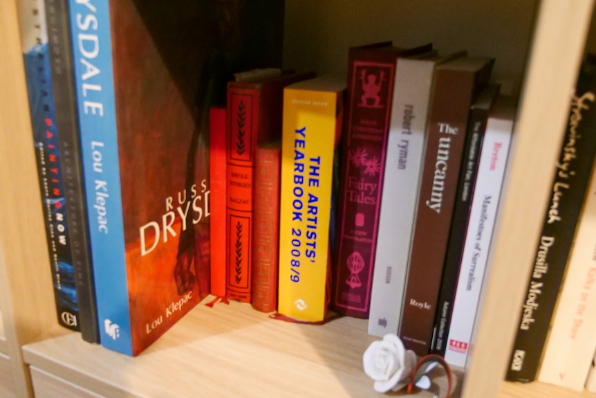 A book shelf full of coloured books