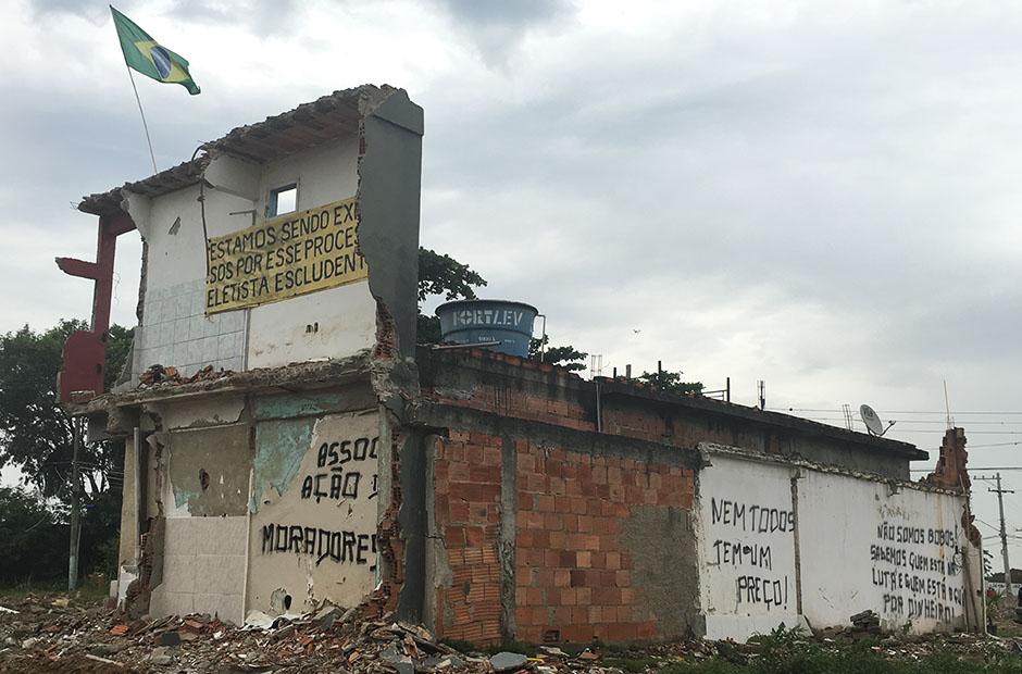 The Brazilian flag flying over a half demolished building at Vila Autodromo.