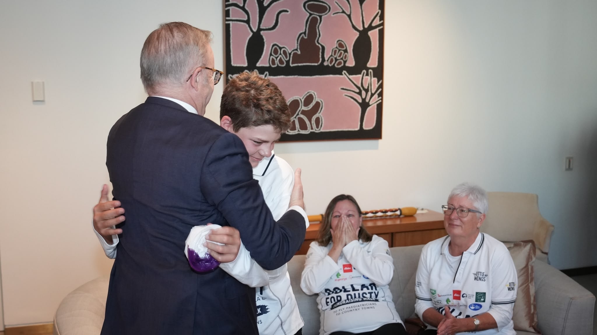 A little boy hugs a man.
