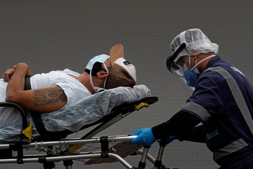 Un operatore sanitario trasporta un paziente su una barella.