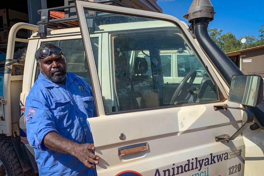 Constantine Mamarika in a blue work shirt opens the door of his 4 wheel drive.