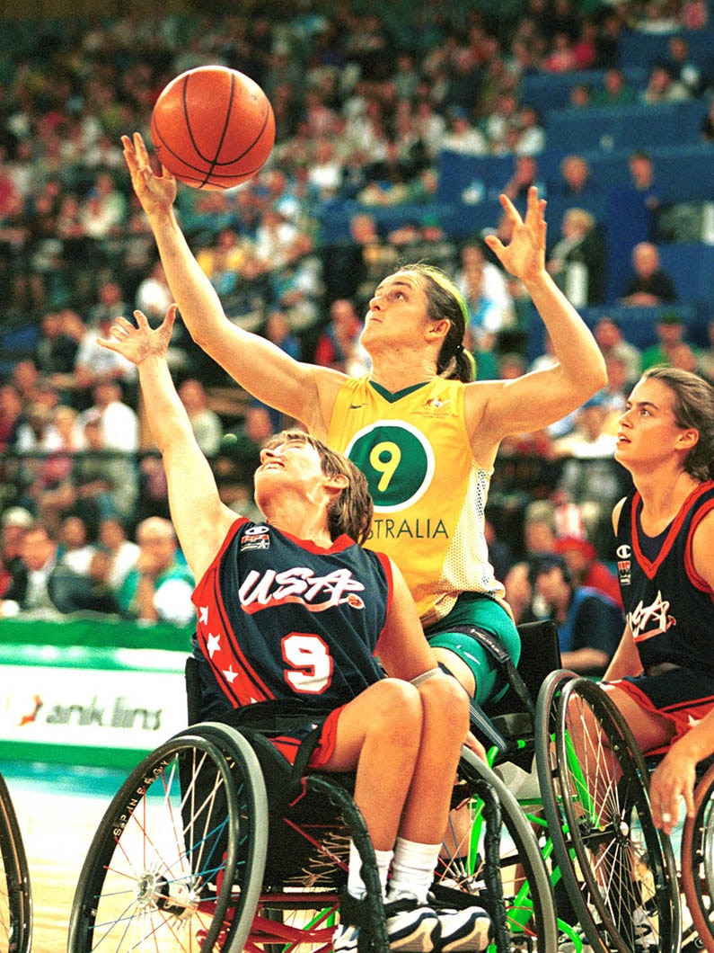 Three female wheelchairs basketball players in action