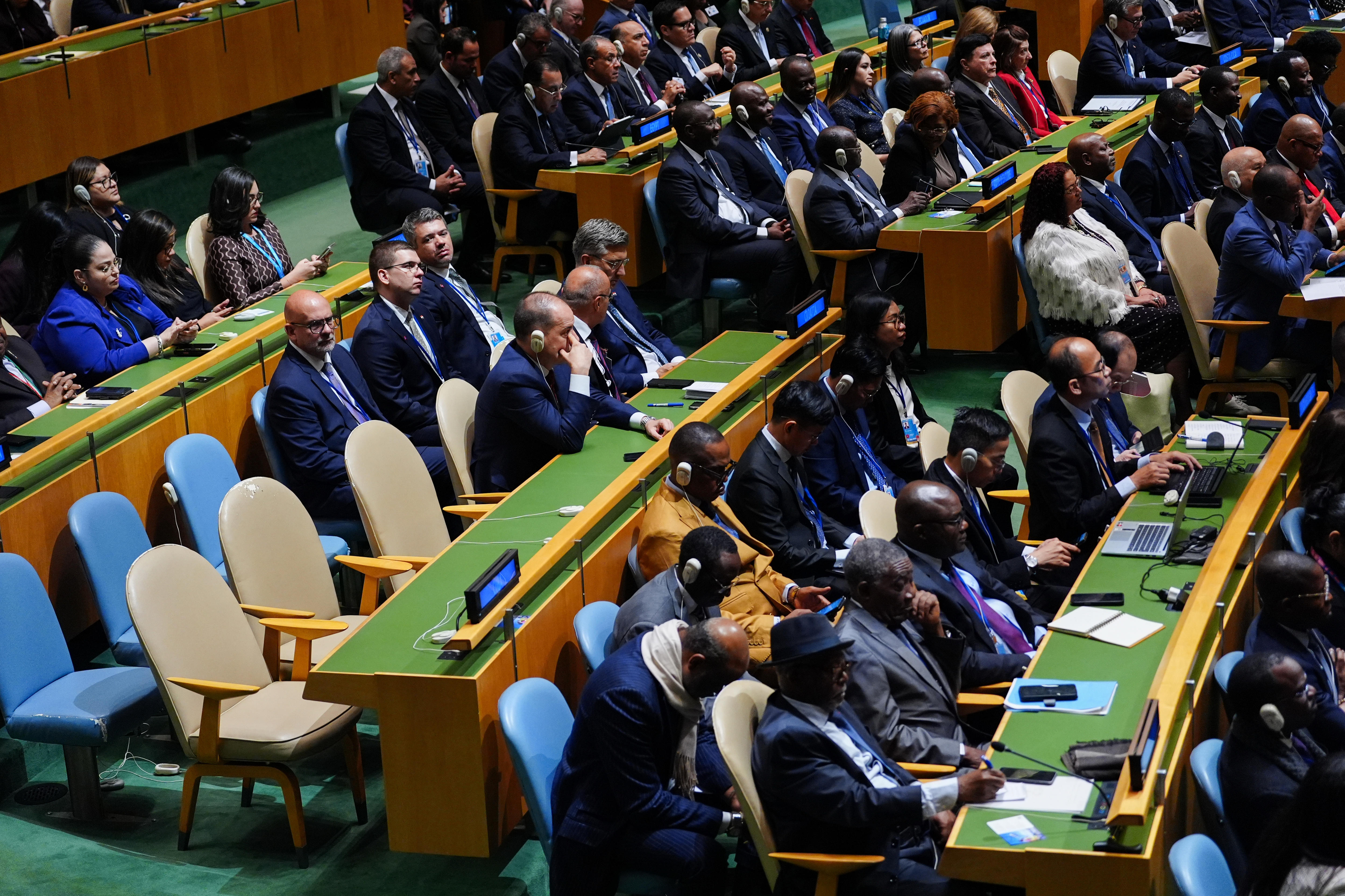 A block of empty seats in an assembly hall, where all other seats are full.