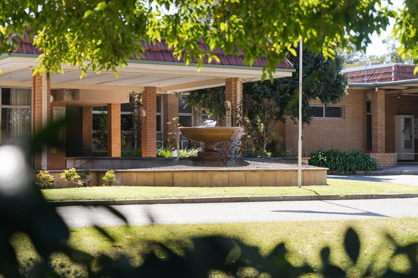 A building with a fountain out the front.