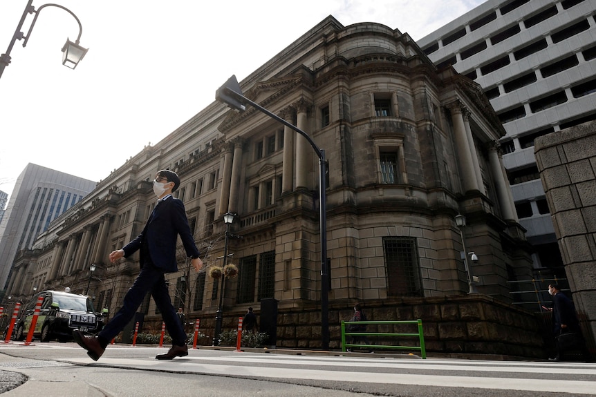 a man walks past the Bank of Japan headquarters in Tokyo