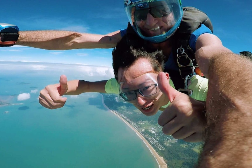 Shengwei Ye skydives in Australia during a trip here in 2019. Land and the shore can be seen below.