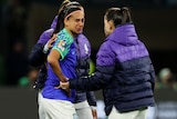 Brazilian footballer Andressa cries and is is comforted by teammates.