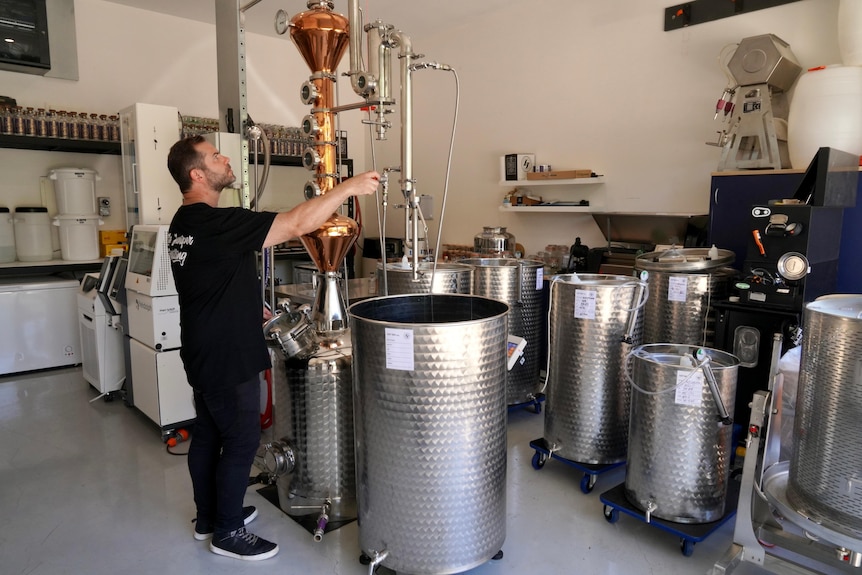 A man distills with containers in front of him.