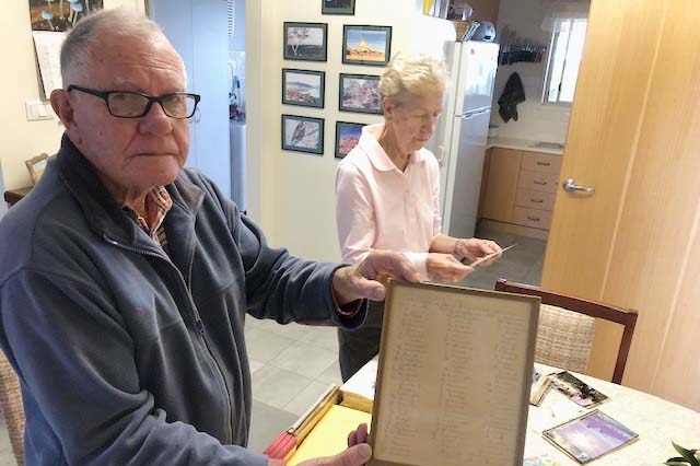 Warren Bottrell and his wife looking through archives in their home.