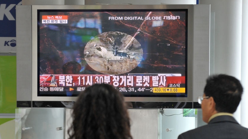 South Koreans watch a North rocket launch