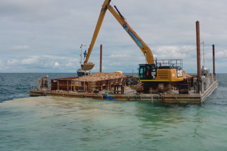 Photo of a large barge is used to bring in huge limestone blocks.