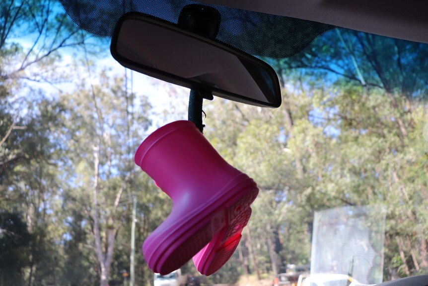Little pink boots hang off Louise Fisher's rear vision mirror