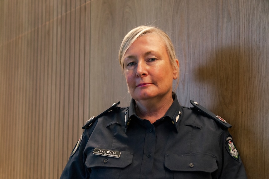 Tess Walsh, who has blonde hair pulled back and is wearing a navy police uniform, poses for a photo