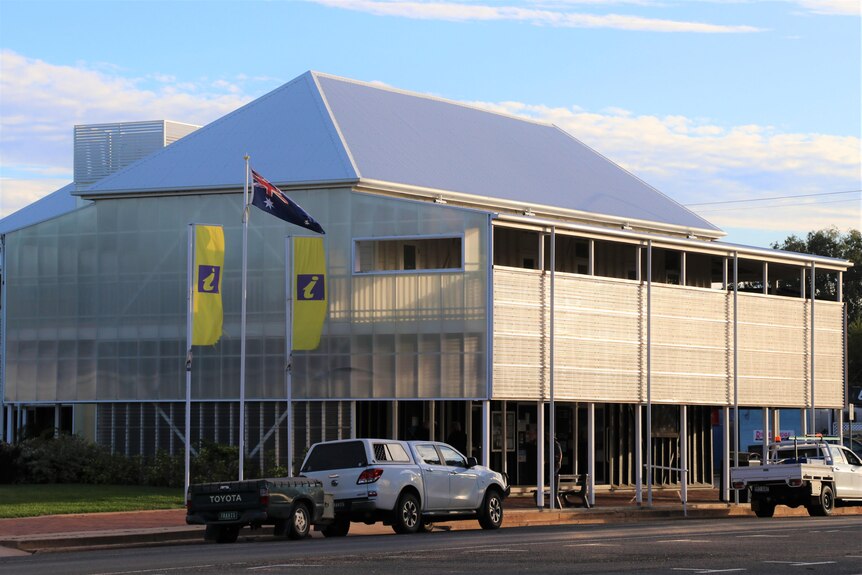 A white two story building with the Australian flag flying on a pole at the front.