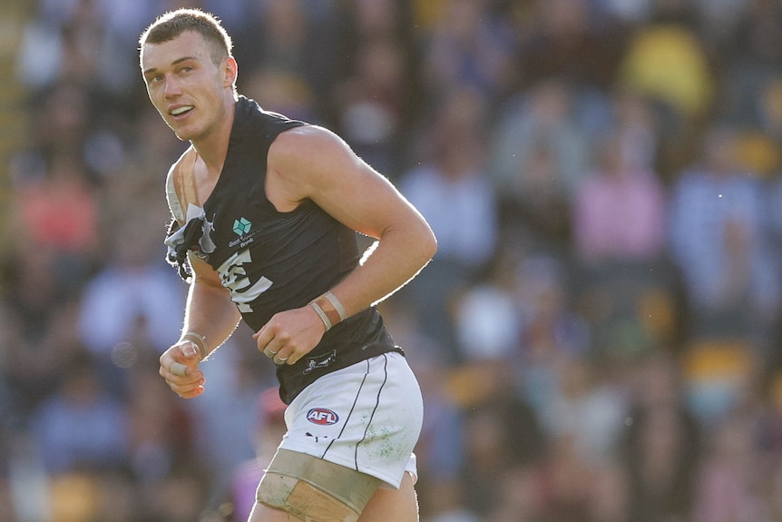 Patrick Cripps runs with his jersey torn heavily at the shoulder