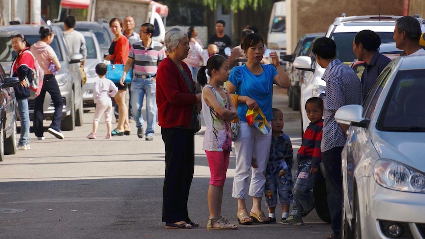 People take shelter on a street in downtown Dingxi after an earthquake