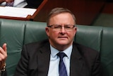 Joel Fitzgibbon yells across the House of Representatives chamber as he sits alongside Anthony Albanese