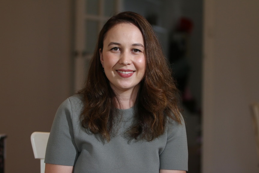 AMP Capital senior economist Diana Mousina sitting in a chair smiling at the camera.