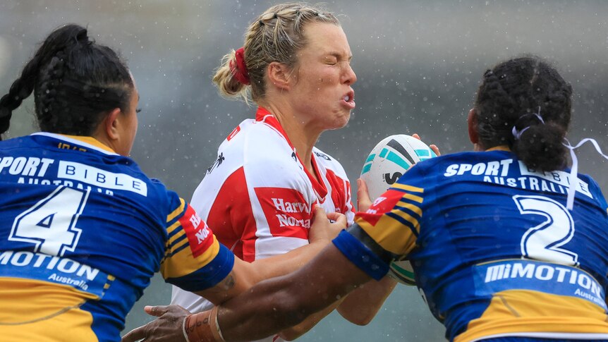 A St George Illawarra NRLW player is met by two Parramatta defenders.