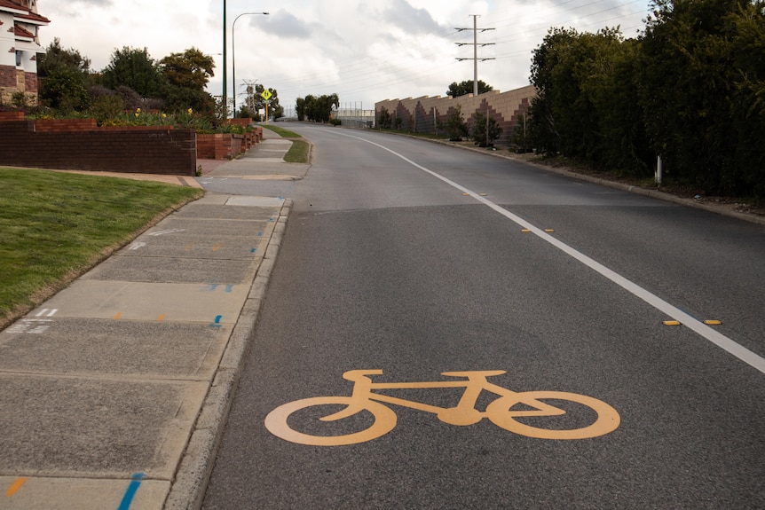 Road with bike sign going uphill