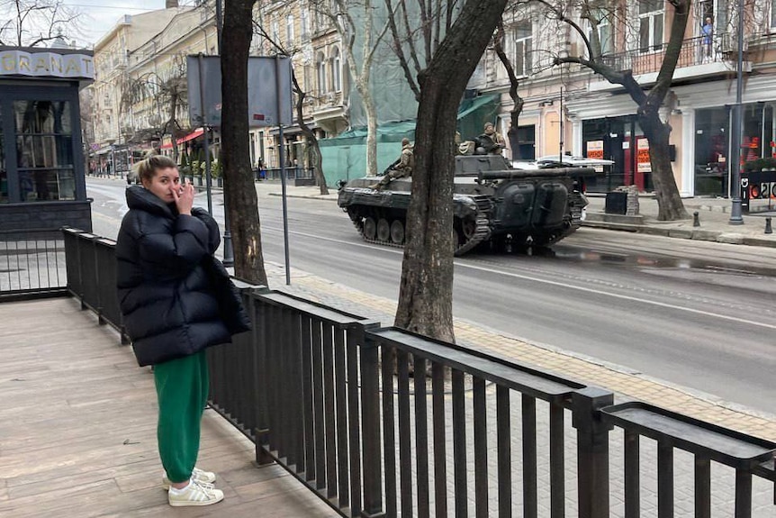 An army tank drives in an Odesa street.