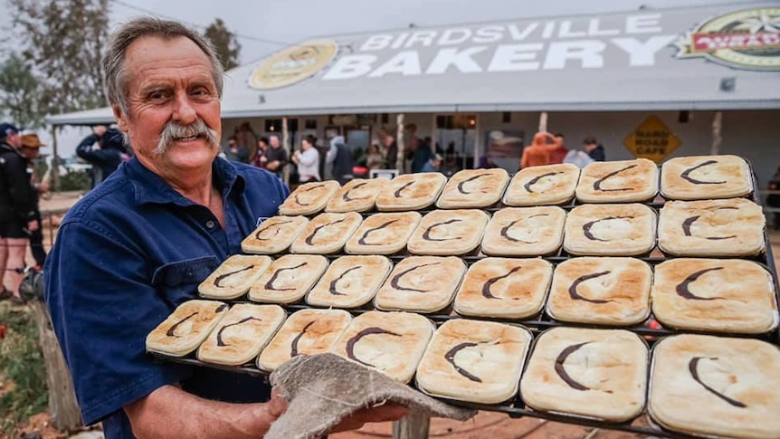 Robert 'Dusty' Miller holding a tray of camel pies