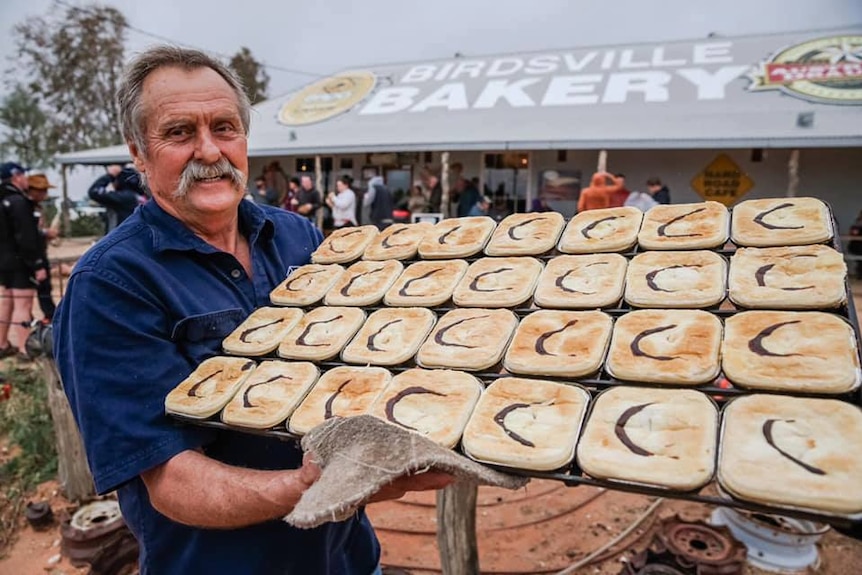 Robert 'Dusty' Miller holding a tray of camel pies