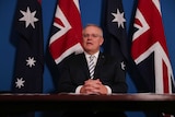 Scott Morrison sits at a table with his hands clasped.