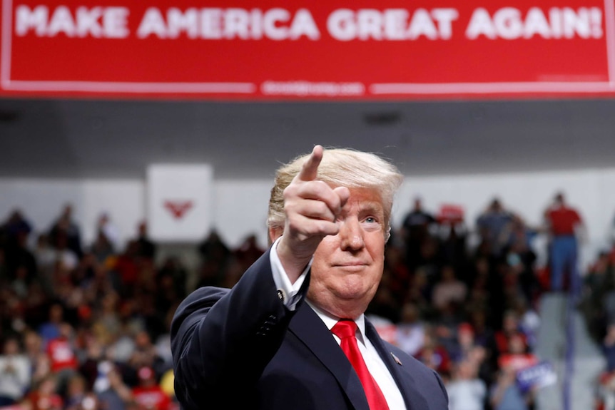 US President Donald Trump reacts at a Make America Great Again rally.