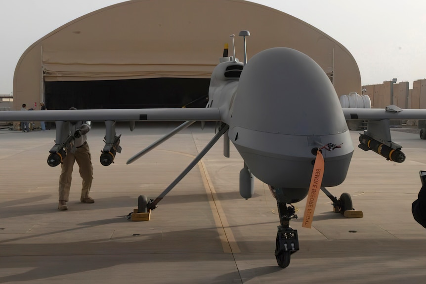 Un soldat pousse un missile d'un mètre de long en position sur un avion