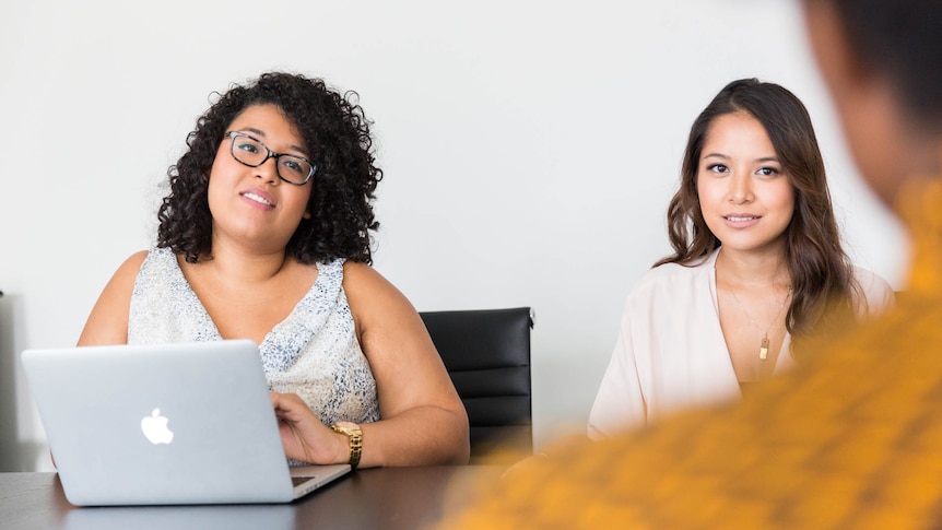 Two women in a meeting in a story about how and when to say no at work.
