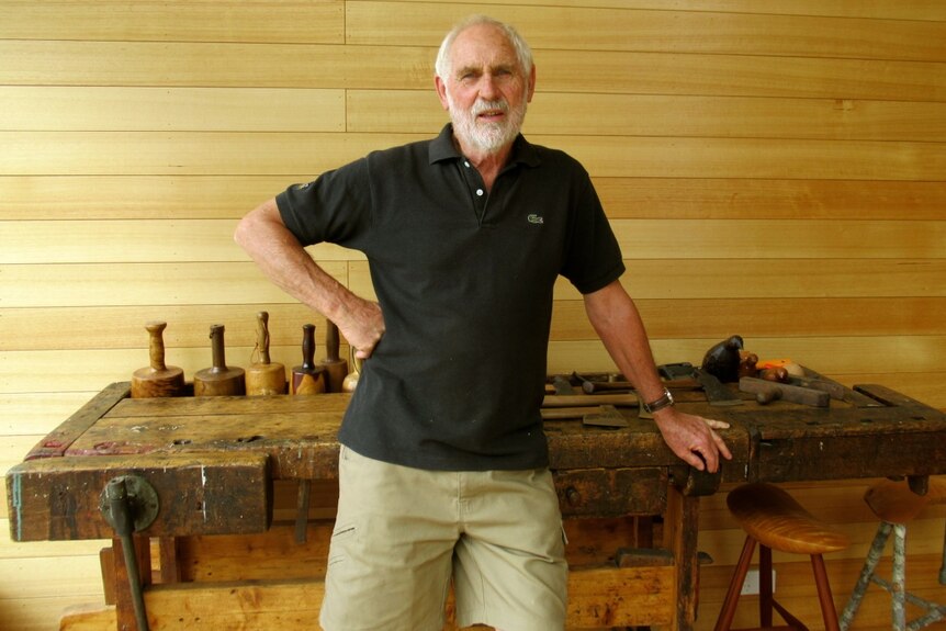 Artist Kevin Perkins stands at a workbench