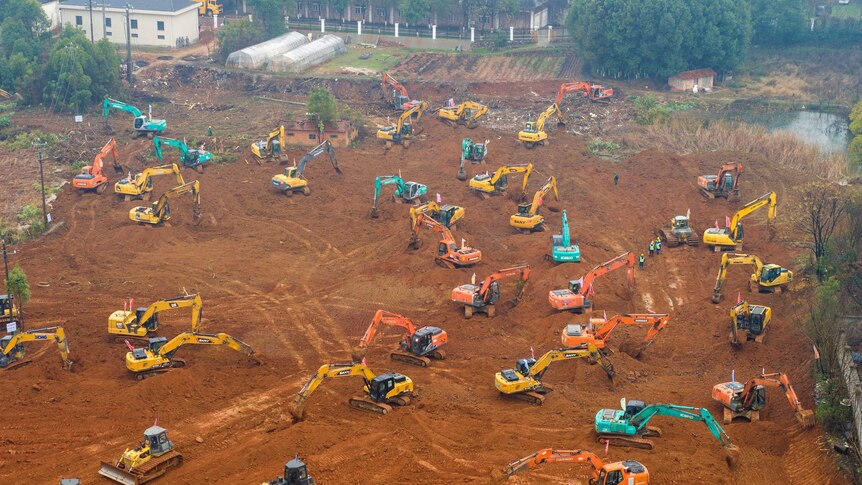 Heavy equipment works at a construction site for a field hospital in Wuhan.