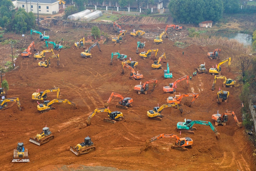 Heavy equipment works at a construction site for a field hospital in Wuhan.