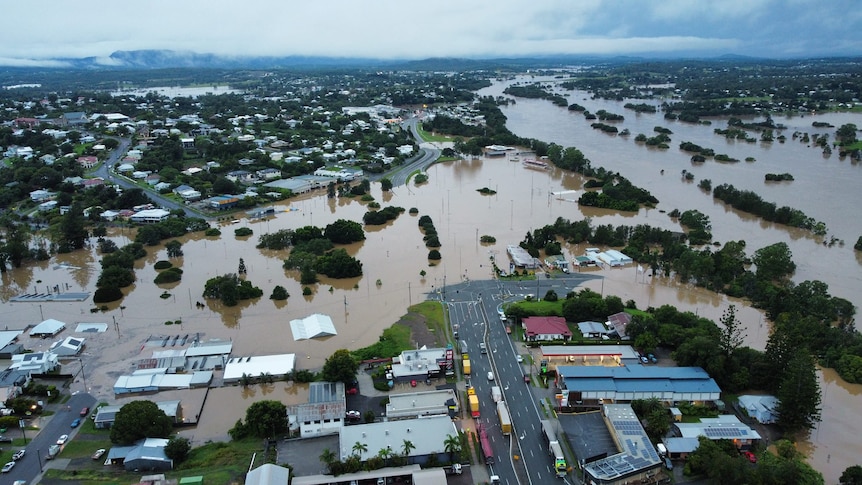 Aerial view showing dark clouds over flooded Gympie streets, properties and roads