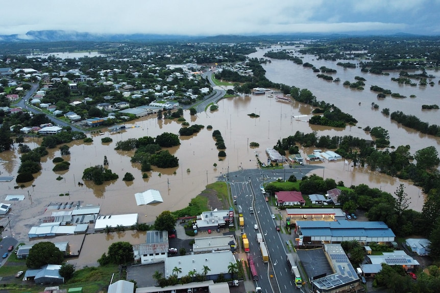 Aerial view showing dark clouds over flooded Gympie streets, properties and roads