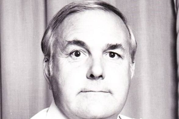 A black and white image of a man in military shirt looking at the camera