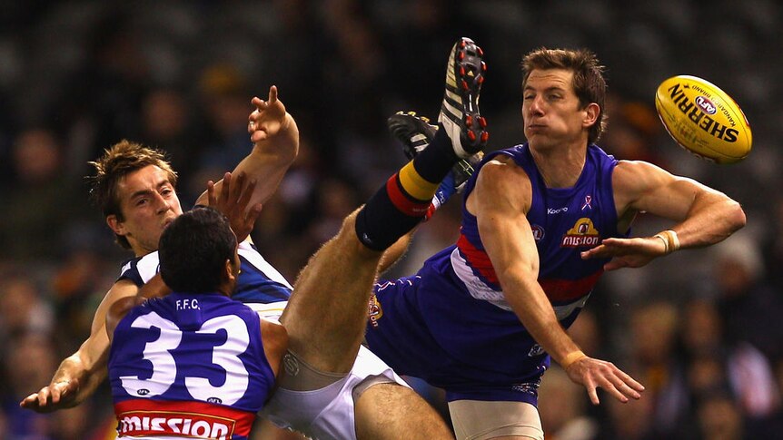 Getting into the scrap ... the Bulldogs defence hits the Crows' Richard Douglas at Docklands.