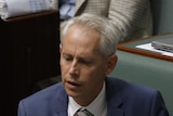 Andrew Giles looks down while sitting in question time in the house of representatives