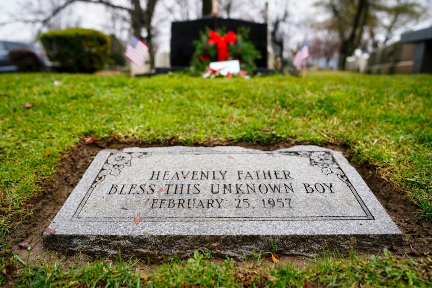 A grave's plaque reads "Heavenly father bless this unknown boy February 25 1957"