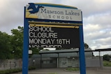 A sign outside a school with an electronic message saying it is closed